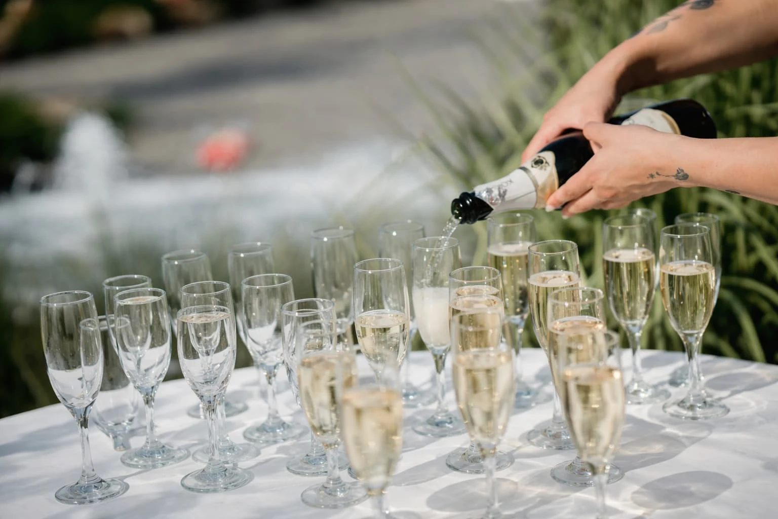 Bartender pouring champagne into flutes for guests during bar service catering in Baltimore, MD