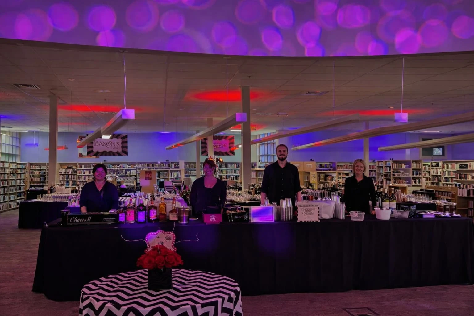 Professional bartenders serving cocktails behind a full-service bar setup at an indoor event in Baltimore, MD