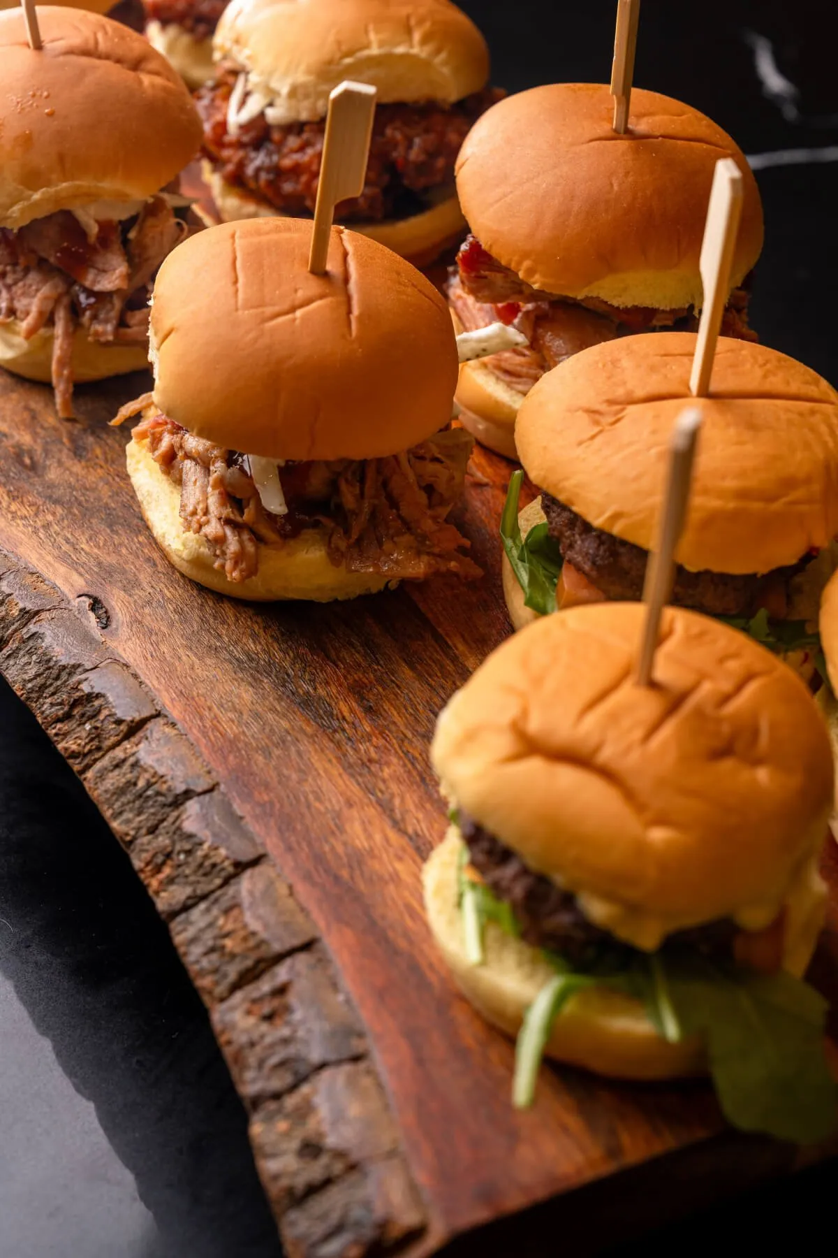 Pulled pork sliders on a rustic wood board from Evolved Catering Baltimore